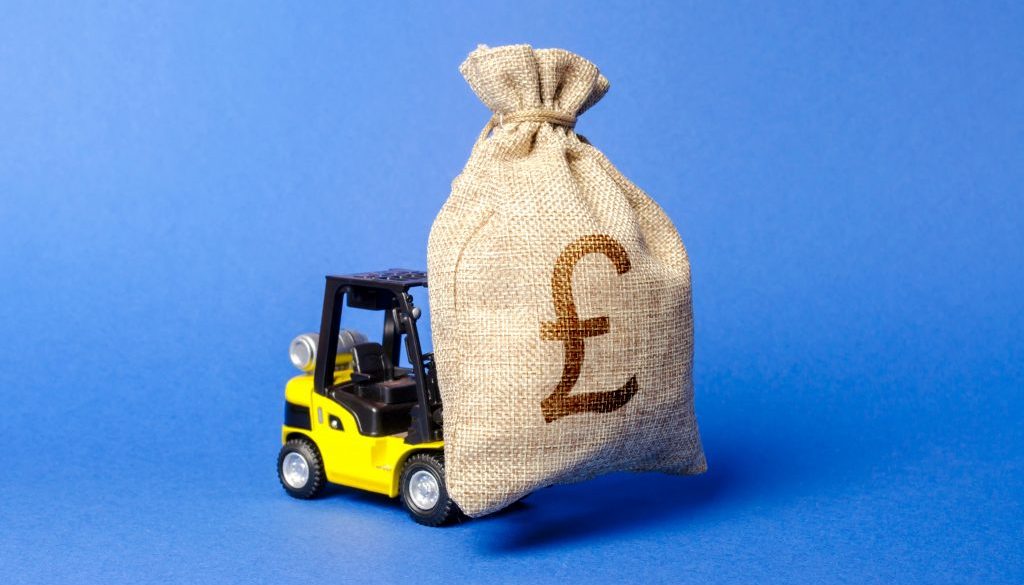 Yellow forklift truck carries a bag of pound sterling. Attracting investment in development, modernization of production and business. Revenue, profit, liquidity. profit fixation. capital migration