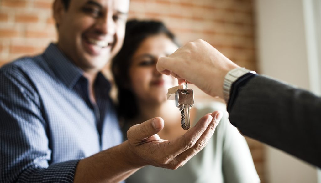 Cheerful couple with keys to their new home