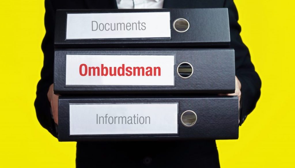 Ombudsman – finance/economics. Man carries a stack of 3 file folders. A folder has the label Ombudsman. Business, statistics concept