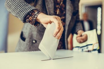 Person casting a ballot at a polling station