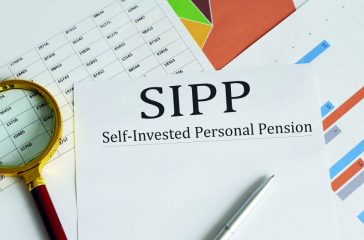 Paper with Self-Invested Personal Pension SIPP on a table with chart, pen and magnifier