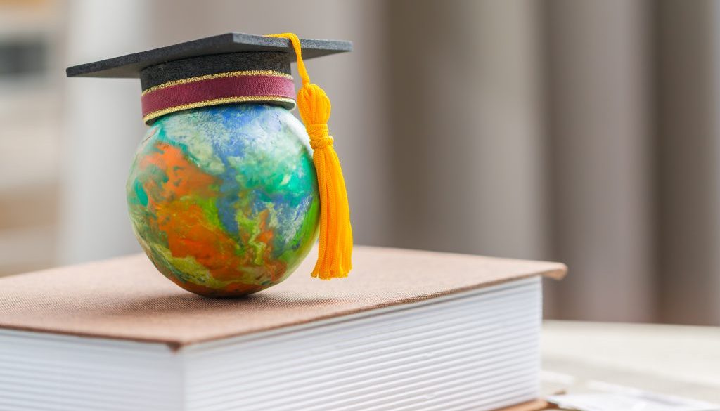 Education to learn study in world. Graduated student studying abroad international idea. Master degree hat on top globe book. Concept of graduate educational for long distane learning anywhere anytime